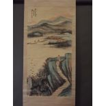 A Chinese watercolour scroll depicting figures in a riverside landscape, 26" x 52"