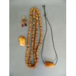 A collection of amber and amber style beads, pendants and earrings, largest 2"