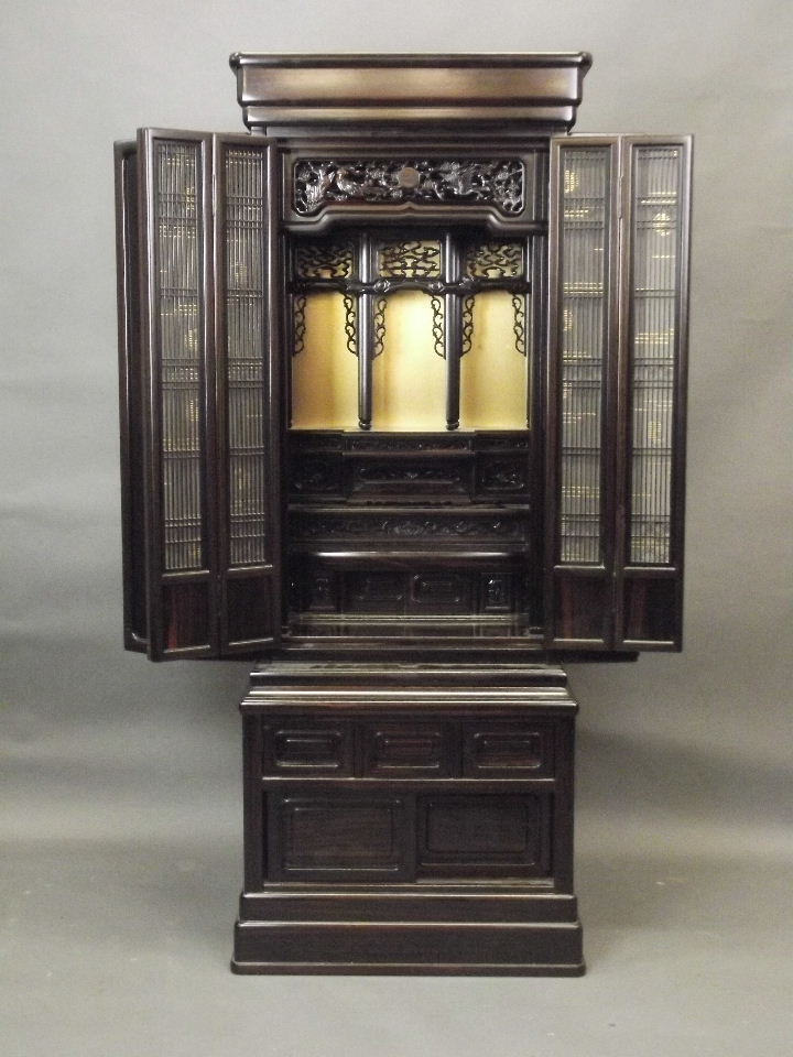 A Chinese hardwood Butsudan shrine cabinet with sectional interior enclosed by two grilled doors