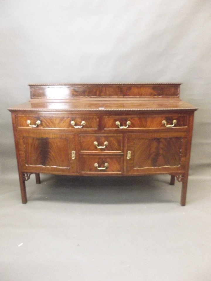 A Georgian style mahogany bow fronted sideboard with two drawers over two cupboards flanking two