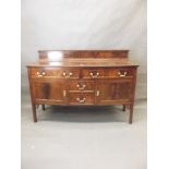 A Georgian style mahogany bow fronted sideboard with two drawers over two cupboards flanking two