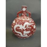 A Chinese red and white twin handled moonflask with incised dragon decoration, 12" high