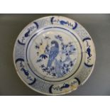 An early C18th Delft blue and white charger decorated with an exotic bird and butterflies, 14"