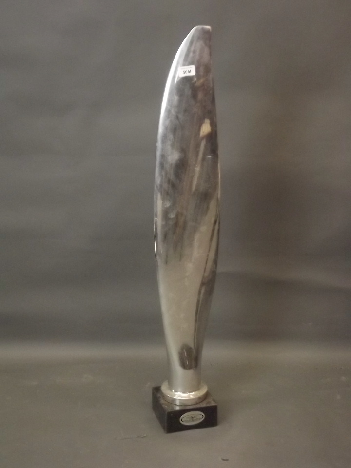 A chromed model of a propeller blade, mounted on a marble base, 38" high