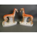 A pair of large Staffordshire pottery figures of greyhounds with game, 11" high