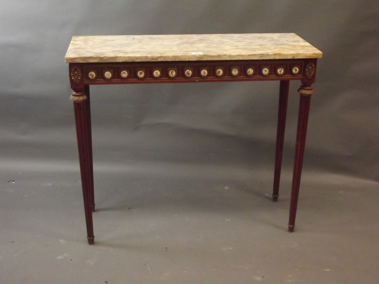A French style mahogany and brass mounted console table with marble top and frieze comprising