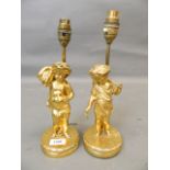 A pair of gilt bronze lamps in the form of cherubs with harvesting tools, 13" high overall