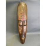 A large African carved wood wall mask with painted animal decoration, c1950, 9½" x 40"
