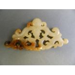 A Chinese jade pendant with carved and pierced archaic decoration of two dragons and a phoenix, 4"