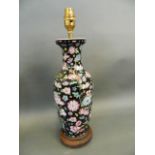 A Chinese porcelain vase decorated with flowers in bright enamels on a black ground, converted to