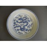 A Chinese blue and white porcelain dish decorated with a dragon chasing the flaming pearl, 6