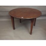 An Edwardian wind-out circular topped dining table raised on square tapering supports with ebony