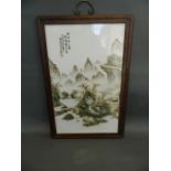 A Chinese famille verte porcelain panel depicting a mountainous river landscape with dwelling, in