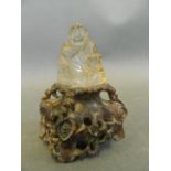 A rock crystal figure of Buddha seated on a carved soapstone base, 4" high