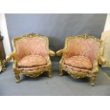 A pair of giltwood easy chairs with carved and pierced frames and scrolled arms, with shaped fronts,
