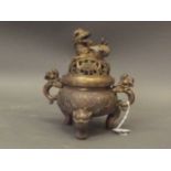 A Chinese bronze censer with twin kylin handles, the pierced cover with kylin knop, raised on tripod