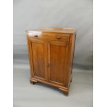 A 1920s mahogany cabinet with single drawer over cupboard and two doors, raised on ogee supports,