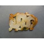 A mottled jade pendant with carved archaic decoration of a dragon, 2" x 3"