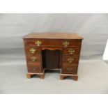 A Georgian mahogany seven drawer kneehole desk with central pigeonhole cupboard and cock beaded