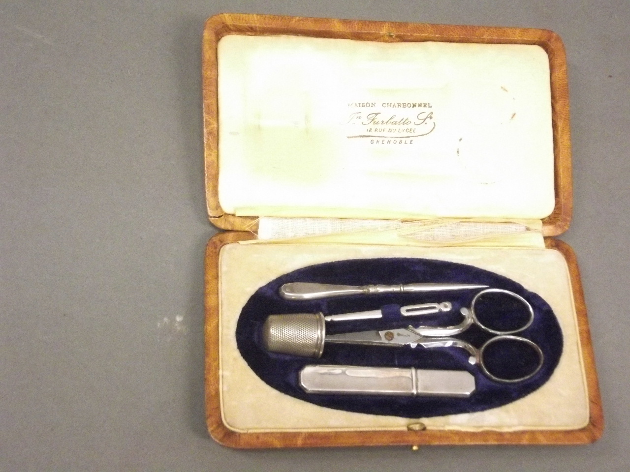 A late C19th manicure set in a leather case, marked 'Maison Charbonnel, Grenoble', 6" x 3"