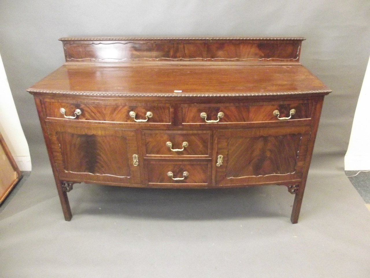 A Georgian style mahogany bow fronted sideboard with two drawers over two cupboards flanking two - Image 2 of 2