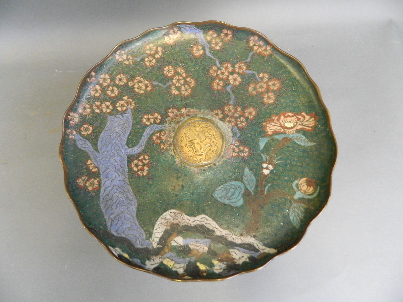 A Chinese cloisonné cake stand with prunus tree and floral decoration, on a brass stand with 6