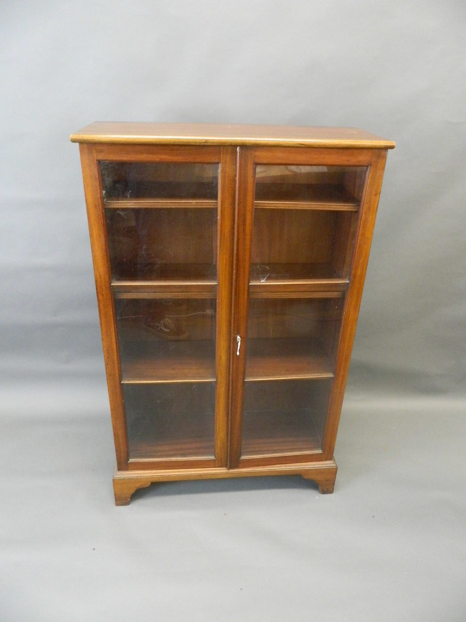 An Edwardian mahogany two door glazed bookcase raised on bracket supports, 30" x 11" x 48" (AF one - Image 2 of 2