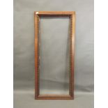 A Victorian walnut mirror frame with egg and dart carved decoration, 27" x 60"