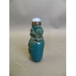 A Chinese blue ground glass snuff bottle with carved dragon and flaming pearl decoration, 3½" high