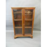 An Edwardian mahogany two door glazed bookcase raised on bracket supports, 30" x 11" x 48" (AF one