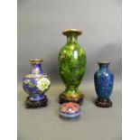 A Chinese green ground cloisonné vase with all over floral decoration, together with two smaller