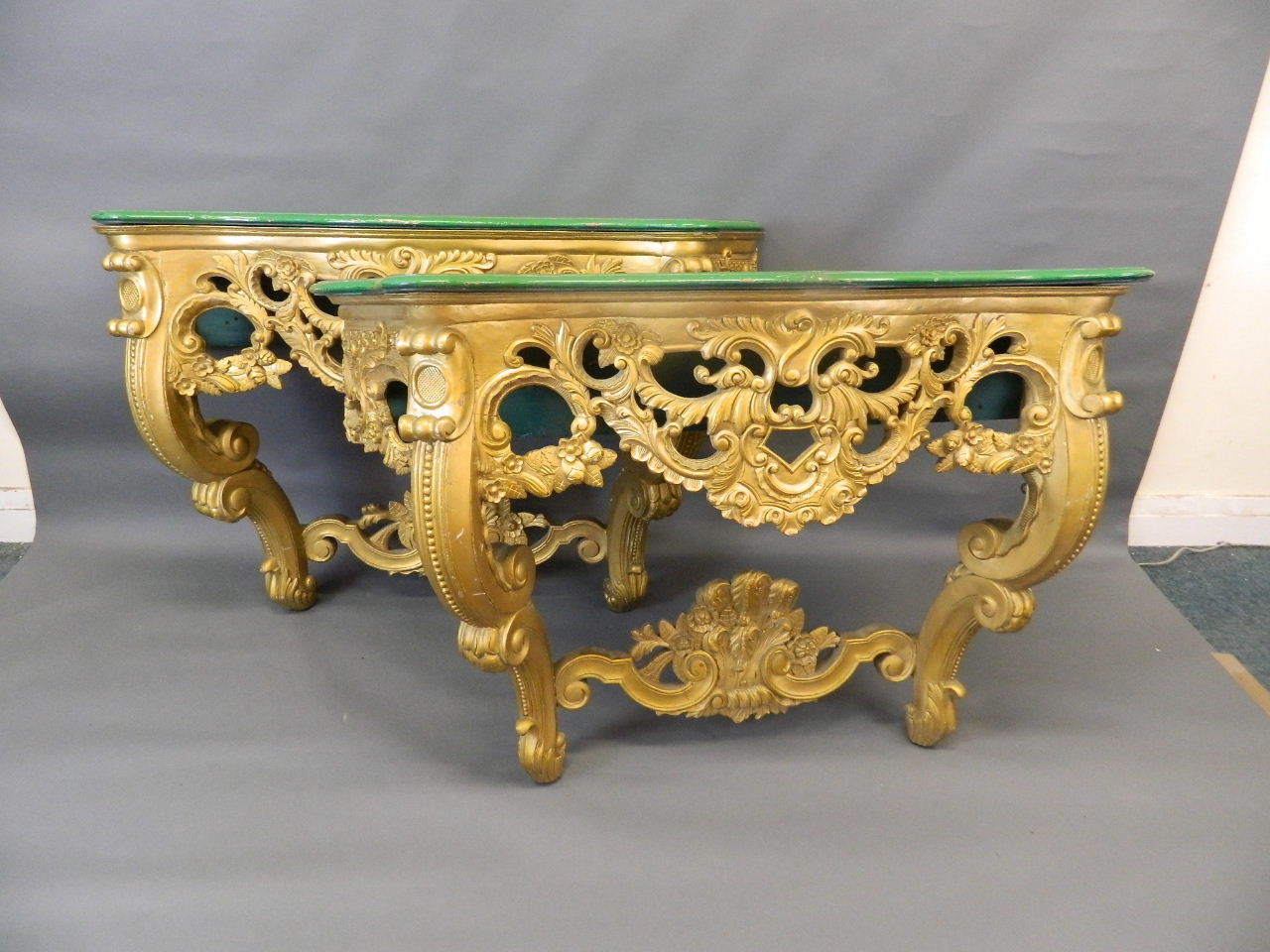 A pair of giltwood console tables with serpentine shaped and carved painted tops, 55" x 18" x 33"