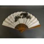 A Chinese bamboo and paper fan with watercolour decoration of a vine bearing fruit, with an