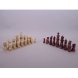 An early C20th complete turned and stained ivory chess set with a mahogany case