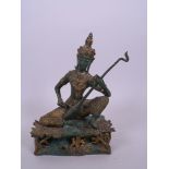 A Thai bronze figure of a musician in traditional garb with green and gilt patina, 8" high