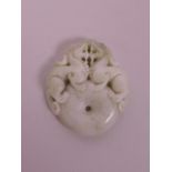 A Chinese light green jade pendant with carved decoration of dragons on a pi disc, 1½"