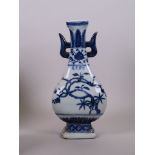 A Chinese blue and white porcelain two handled vase with flowering tree decoration, four character