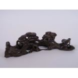 A Chinese carved hardwood brush rest in the form of a tree root, 8" long