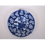 A Japanese blue and white porcelain plate, with decorative panel depicting vases on a cracked ice