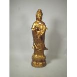 An Oriental gilt white metal figure of Quan Yin, 39" high