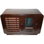 An Ekco type A23 wireless receiver, 1946, brown Bakelite version, with period cloth and five pre-