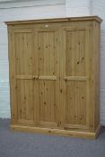 Pine triple wardrobe wth three panelled doors on plinth base,W163cm, H198cm,