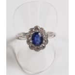18ct white gold oval sapphire and ten diamond cluster ring in millegrain setting
