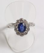 18ct white gold oval sapphire and ten diamond cluster ring in millegrain setting