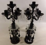 Pair of black glass four branch candelabras with drops and a pair of similar candle sticks