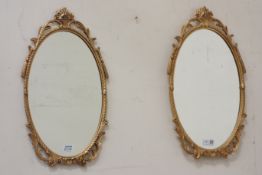 Pair of gilt metal framed oval wall mirrors,