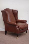 Laura Ashley wing back armchair upholstered in brown leather with mahogany feet and brass castors