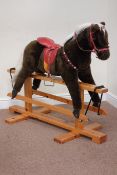 Late 20th century rocking horse on polished pine base,