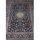 Persian Kashan rug, central rosette medallion, blue field covered in floral decoration,