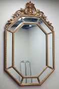 Octagonal wall mirror in gilt frame with sectional mirrored border and ornate pediment, W88cm,